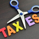 scissors and colorful letters spelling out the word, "TAXES"