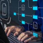 Document Management System (DMS) being setup by IT consultant working on laptop computer in office