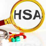 Magnifying lens with text HSA with medical tools and pills