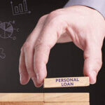 Hand placing block on other blocks with words, "person loan" on block