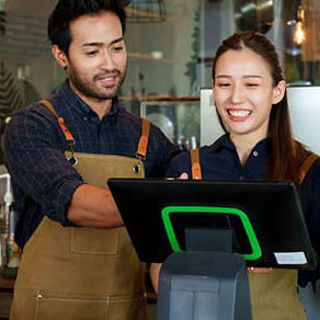 Man and women at a coffee shop standing in front of the checkout key pad