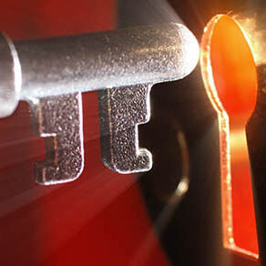 keyhole with light coming from it and old key going into it