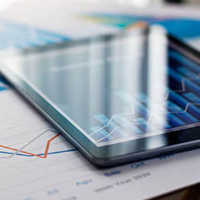 Business document report on paper and tablet with sales data and financial business growth graph on table background.