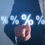 Person in suit pointing finger and touching glowing percent signs