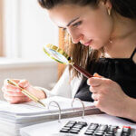 Fraud Investigation And Tax Audit. Investigator Or Auditor Using Magnifying Glass