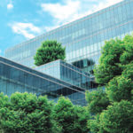 Outside of a mirrored building lined with trees