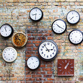 Collection of vintage clock hanging on an old brick wall