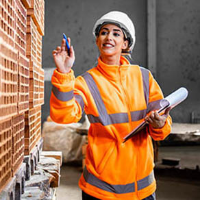 Industrial female worker checking inventory of bricks ready to deliver to the construction site.