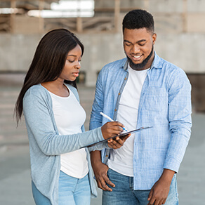 Woman standing next to man asking question and writing down the answer