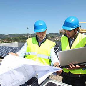 Group of engineers meeting and reviewing plans outside