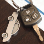Close up of a car key with a metal car keychain