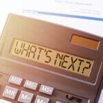 Calculator with the inscription - WHAT S NEXT against the background of financial statements