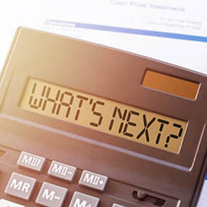 Calculator with the inscription - WHAT S NEXT against the background of financial statements