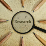 Word Research under a magnifying glass on vintage background