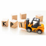 Toy forklift picking up the letter block "q" to complete word kpi