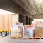 Bulk pallets of packaging boxes being loaded onto a container truck
