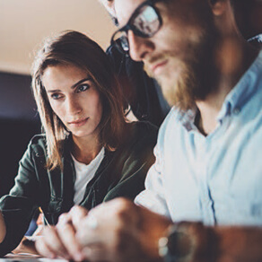 A couple sitting close looking intently at a computer screen
