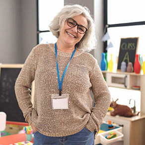Teacher in a classroom standing with hands on her hips