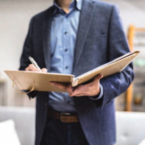 Business man holding padfolio open and making notes
