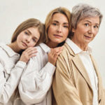Three generations of women standing closely together
