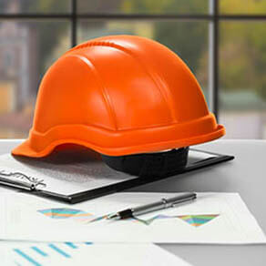 Construction hat on top of construction documents on a desk