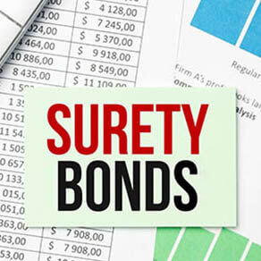 On the desktop there are reports, notepads, a calculator, a cash and a yellow sticker with the text SURETY BOND. Business concept
