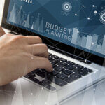 technology and business concept: man using a laptop with budget planning software on the screen. All screen graphics are made up.