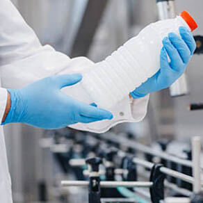 Man worker operator inspecting milk bottles production line dairy factory industry, automatic conveyor for transporting.