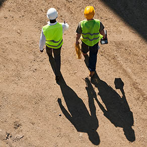 Arial shot of two construction workers walking on a job site