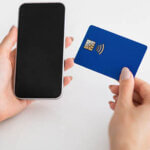 Hands of woman use smartphone with blank screen and credit card