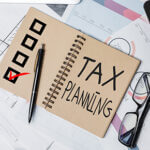 Top view of office desktop with paperwork, glasses and other items. Tax planning concept