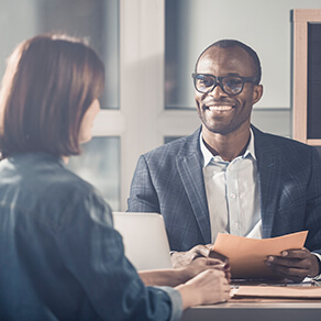 Business man and woman sitting across table from one another in job interview