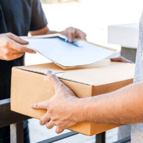 Someone dropping off a box and papers to another person