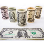 5 rolled dollar bills - one roll each of $2, $5, $10, $20, $50 and a $1 bill laying flat in front of those rolled behind