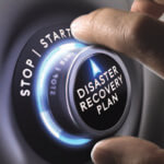 Hand turning a "Disaster Recovery Plan" dial between stop and start