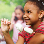 Little girl with marshmallows on a stick