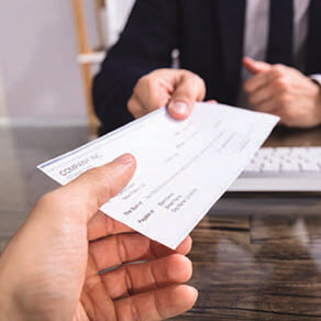 A person is receiving a check from another person.