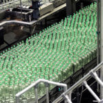 A bunch of green vials on an assembly line