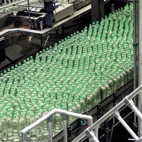 A bunch of green vials on an assembly line