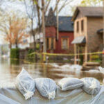 lose shot of flood Protection Sandbags with flooded homes in the background