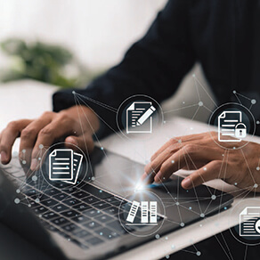 Hands typing on a laptop with graphics over laid