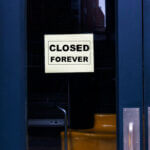 Glass door with sign "closed forever" on it