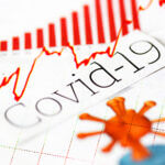 Word Covid-19 written across chart, virus cell in red, red lines, red medical graph