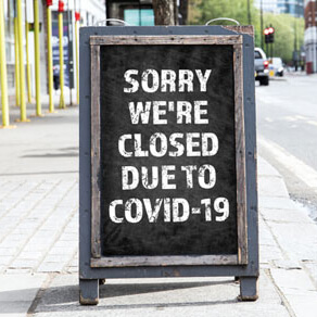 Store sign with words sorry were closed due to COVID-19