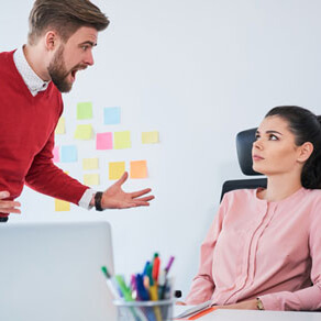 Man yelling at woman sitting in front of her laptop