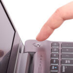 Person pressing power button on laptop