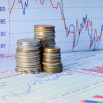 Stacks of coins with financial charts