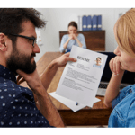 Two people questioning and reviewing resume